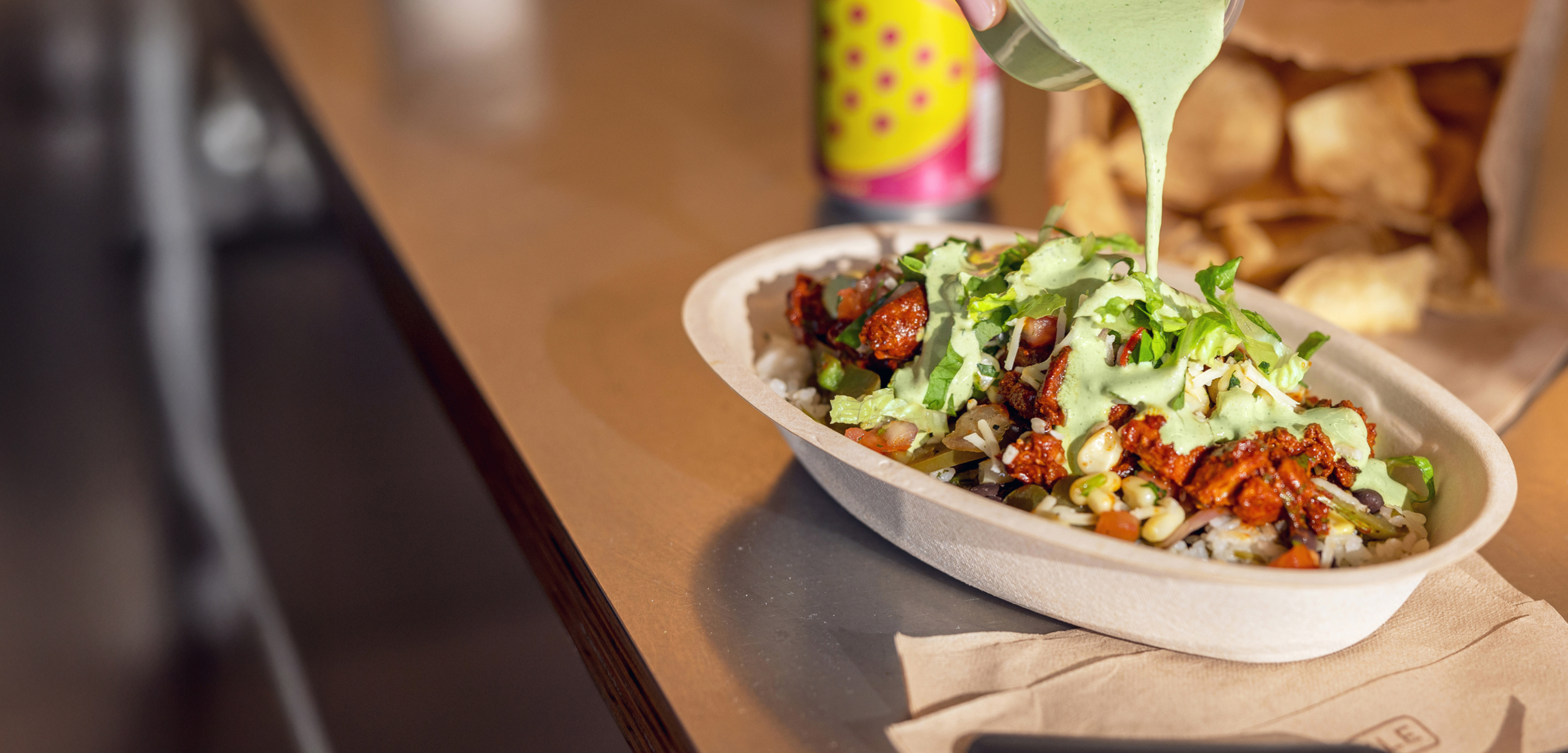 A side of Adobo Ranch on a cutting board around the fresh ingredients that go into it including Chipotle Chili pepper and fresh ranch herbs.
